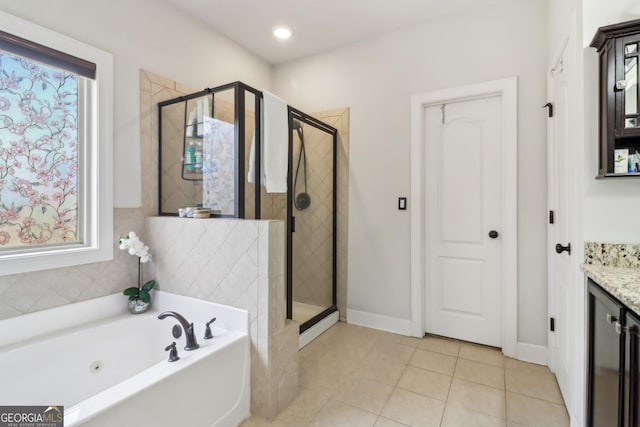 bathroom featuring a stall shower, a garden tub, vanity, and tile patterned floors