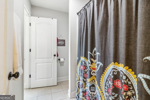 full bath featuring a shower with curtain, baseboards, and tile patterned floors