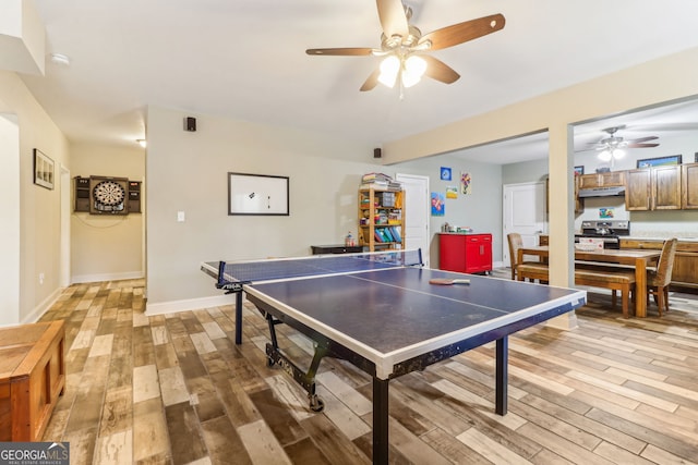 recreation room with light wood-type flooring, a ceiling fan, and baseboards