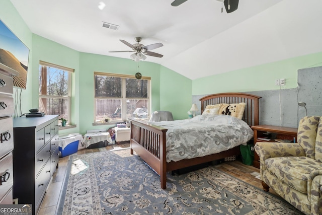 bedroom with vaulted ceiling, ceiling fan, wood finished floors, and visible vents