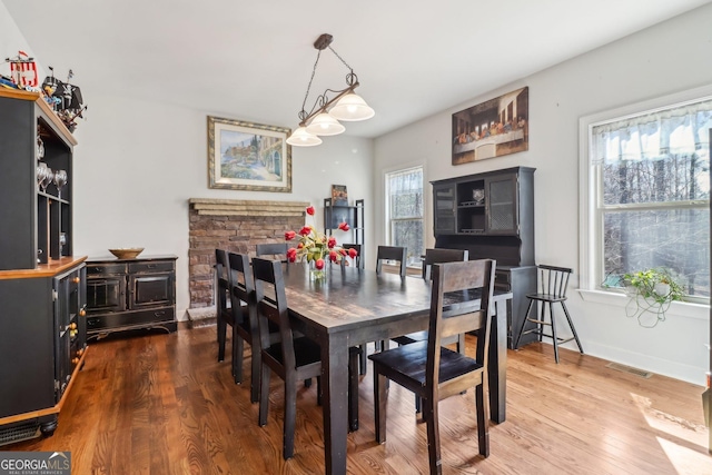 dining area featuring wood finished floors, visible vents, and baseboards