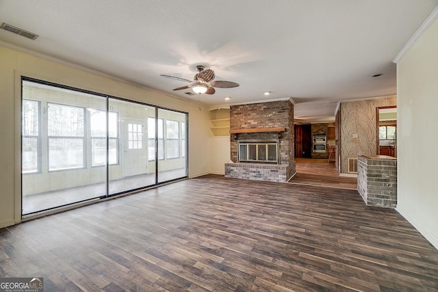 unfurnished living room featuring a fireplace, crown molding, visible vents, and wood finished floors