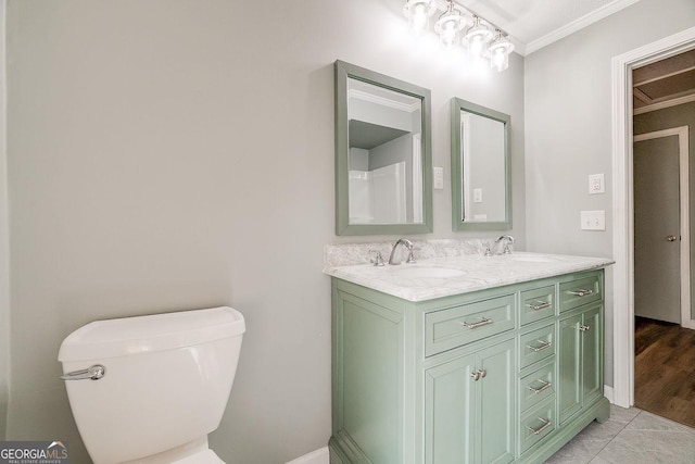 full bath with double vanity, crown molding, toilet, and a sink