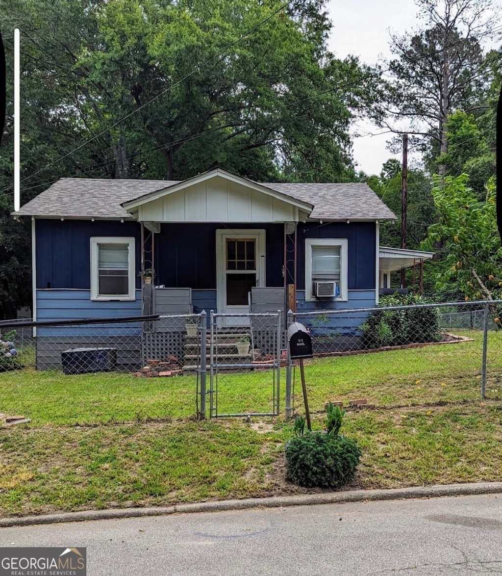 bungalow with a porch, a front yard, a gate, and board and batten siding