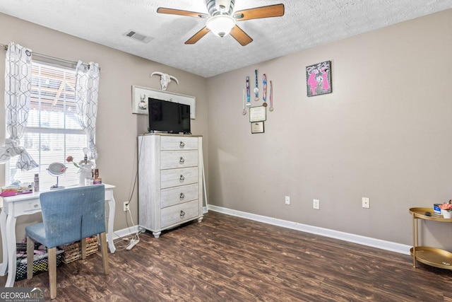 office area featuring dark wood-style flooring, visible vents, ceiling fan, and baseboards