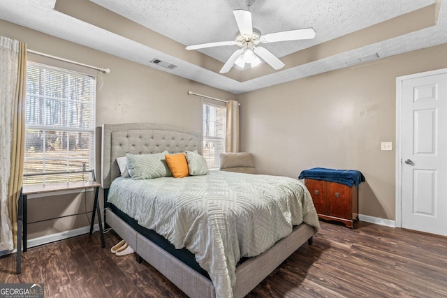 bedroom featuring a textured ceiling, wood finished floors, baseboards, and visible vents