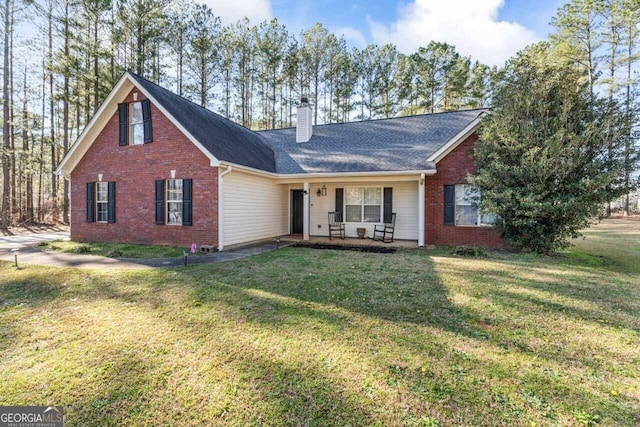 view of front of home featuring a chimney, a front yard, and brick siding
