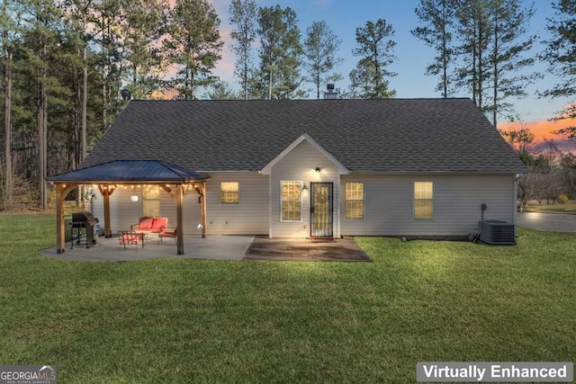 back of house at dusk featuring a gazebo, a lawn, central AC, and a patio