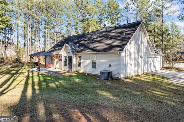 rear view of property featuring a patio, central air condition unit, a yard, a garage, and a gazebo