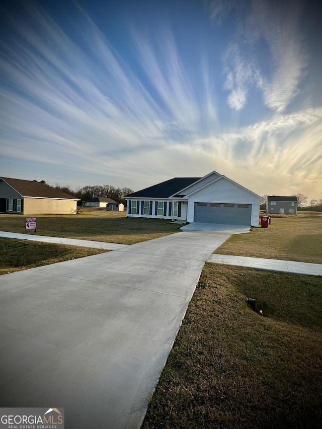 single story home with a front yard, concrete driveway, and an attached garage