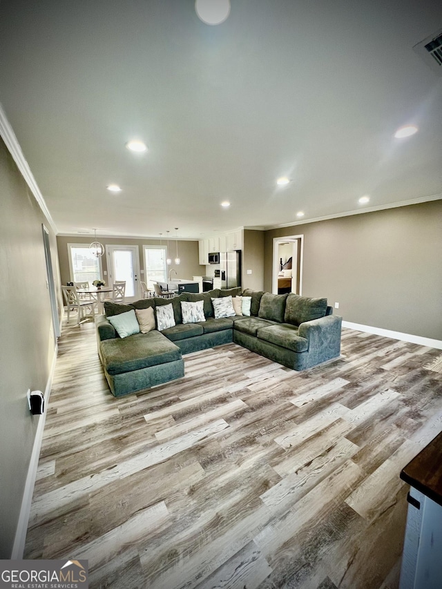 unfurnished living room with baseboards, wood finished floors, and crown molding