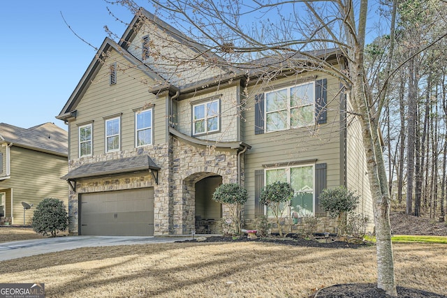 view of front of property featuring driveway, stone siding, an attached garage, and a shingled roof