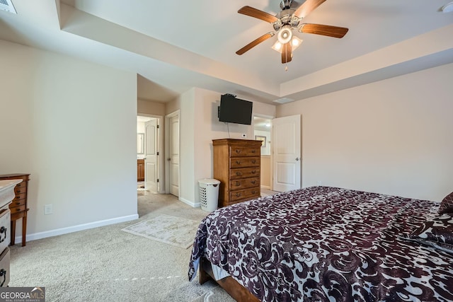 bedroom with ceiling fan, a tray ceiling, carpet flooring, and baseboards