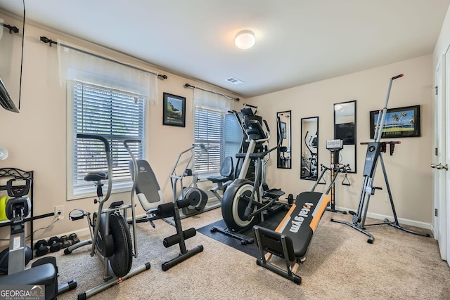 exercise room with carpet flooring, visible vents, and baseboards