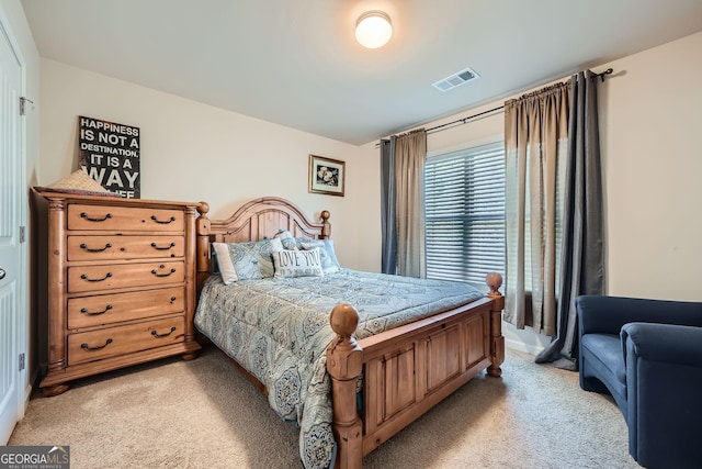 bedroom with visible vents and light carpet