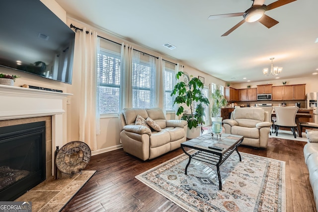 living area with dark wood-style floors, a fireplace, recessed lighting, visible vents, and a ceiling fan