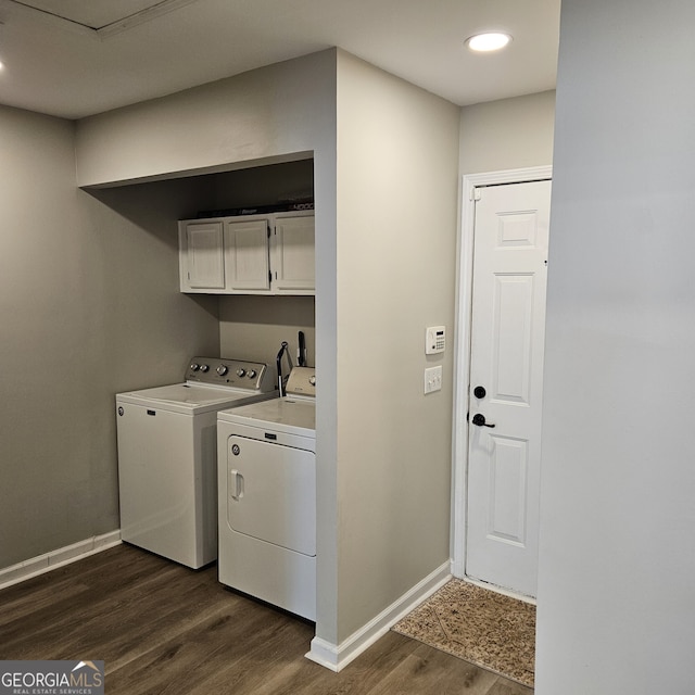 laundry room featuring washer and clothes dryer, dark wood finished floors, cabinet space, and baseboards