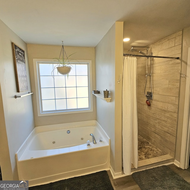 bathroom featuring a stall shower and a jetted tub