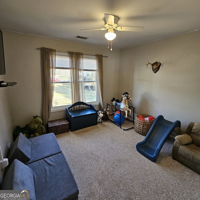 playroom with carpet floors, visible vents, and a ceiling fan