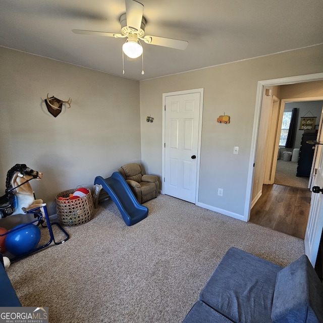 recreation room featuring carpet flooring, ceiling fan, and baseboards