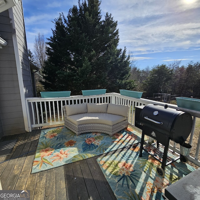 wooden terrace with area for grilling and an outdoor living space