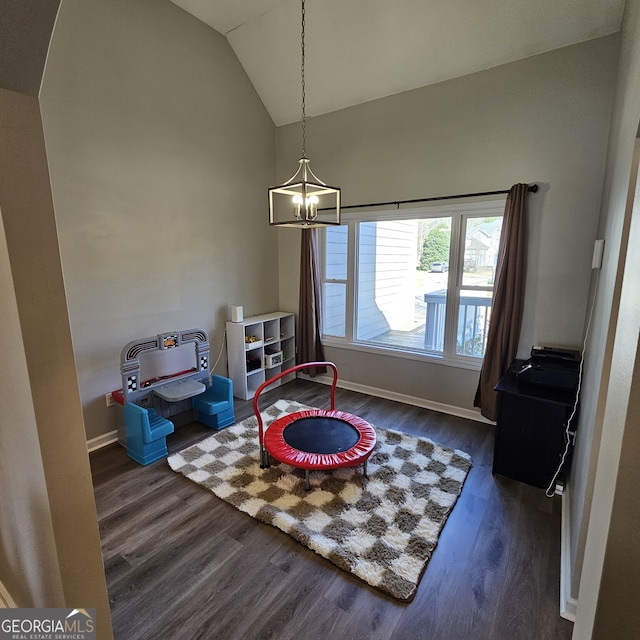 game room with dark wood-style floors, a notable chandelier, vaulted ceiling, and baseboards