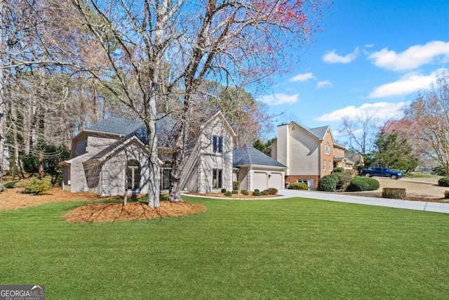 view of front of house with a front lawn, concrete driveway, and an attached garage