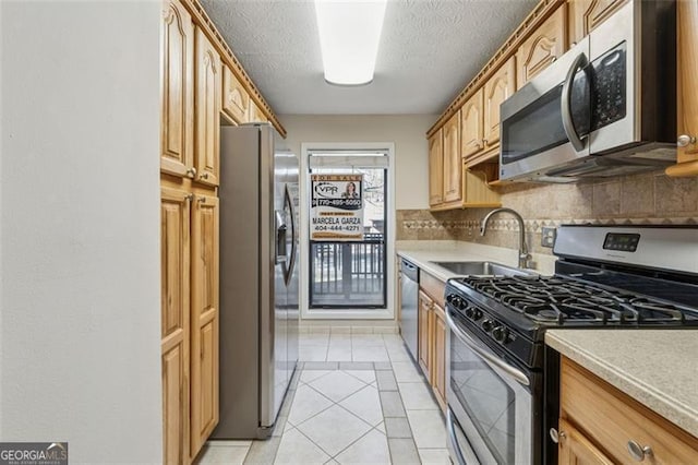 kitchen with light tile patterned floors, stainless steel appliances, a sink, and light countertops