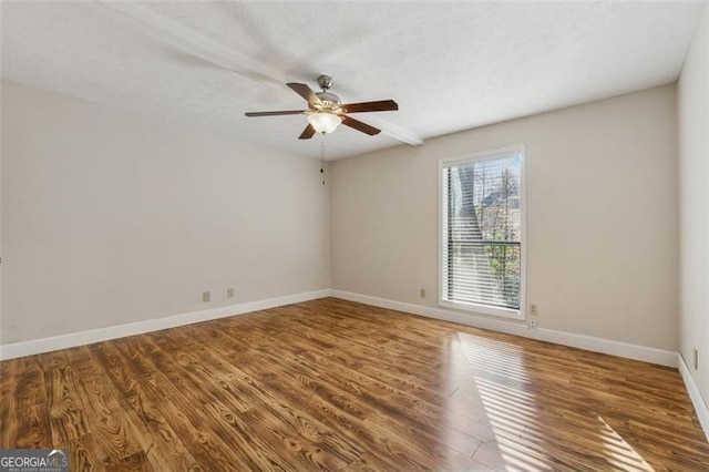 unfurnished room featuring a ceiling fan, a textured ceiling, baseboards, and wood finished floors