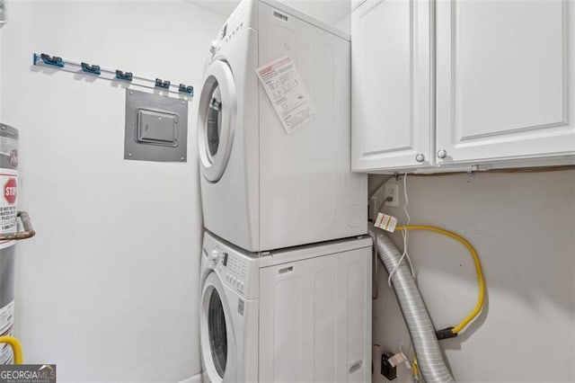 laundry room with cabinet space and stacked washer and clothes dryer