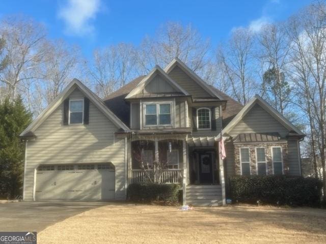 craftsman-style home with a porch, an attached garage, driveway, and board and batten siding