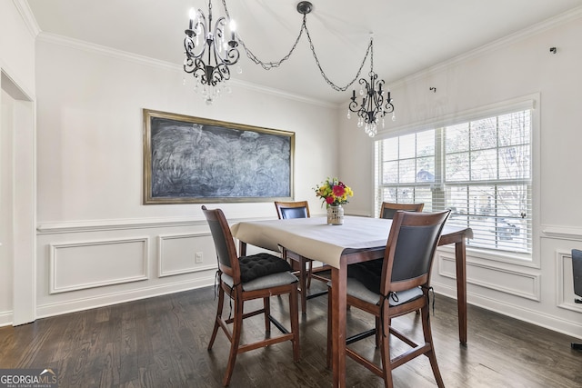 dining area featuring a notable chandelier, ornamental molding, dark wood-style flooring, and a decorative wall