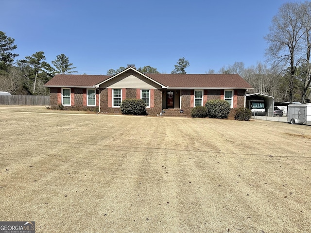 single story home with driveway, brick siding, fence, and a detached carport