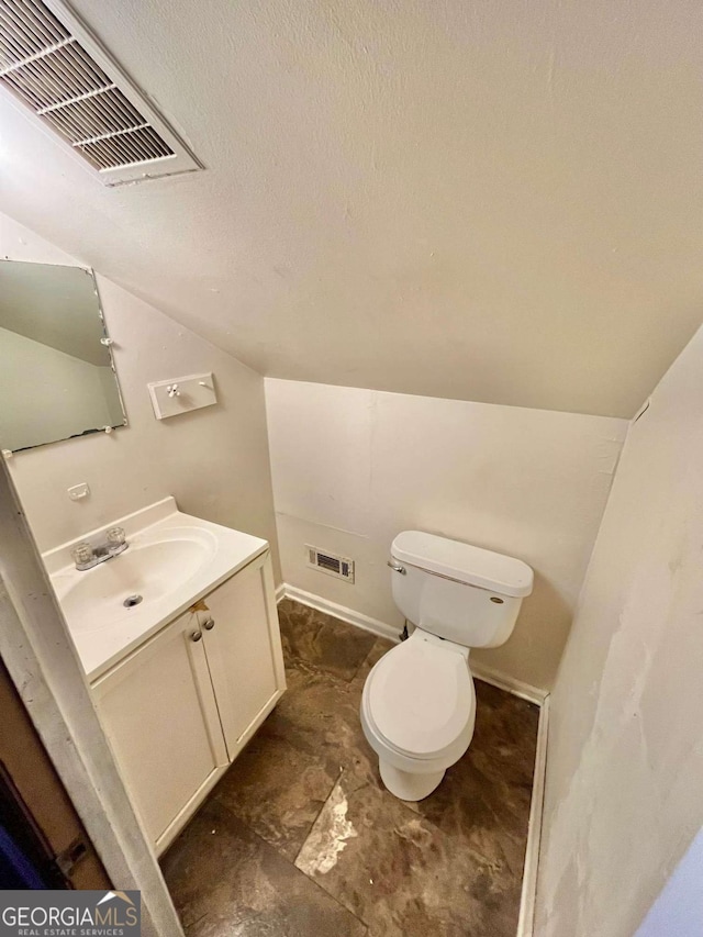 bathroom featuring visible vents, vaulted ceiling, a textured ceiling, and toilet