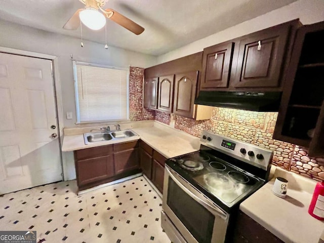 kitchen featuring under cabinet range hood, electric range, a sink, light countertops, and decorative backsplash