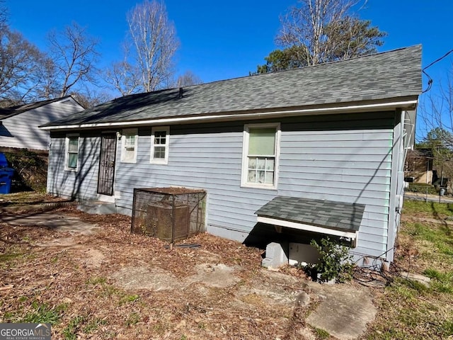 back of house with entry steps and a shingled roof