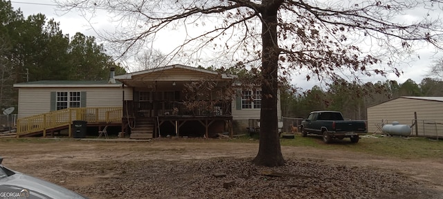 rear view of property featuring stairs and a wooden deck