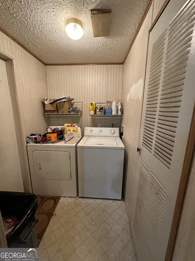 clothes washing area featuring laundry area, tile patterned floors, crown molding, and independent washer and dryer