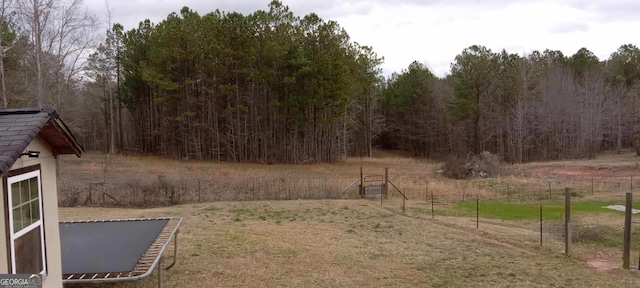 view of yard featuring fence and a forest view