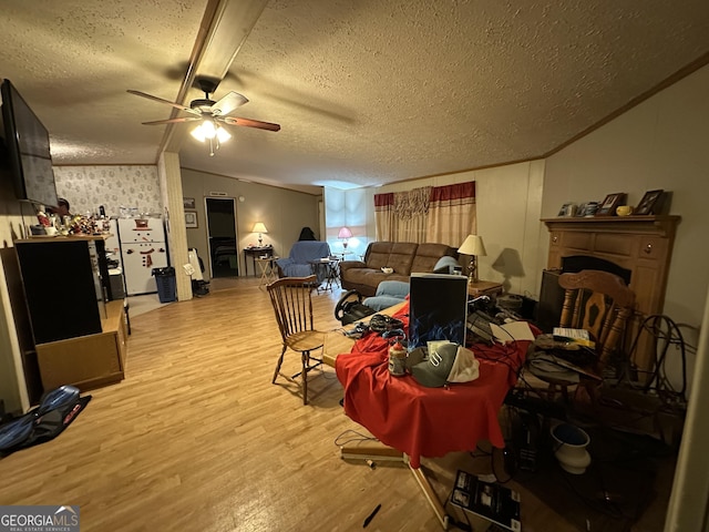 living room with lofted ceiling, crown molding, a textured ceiling, and wood finished floors