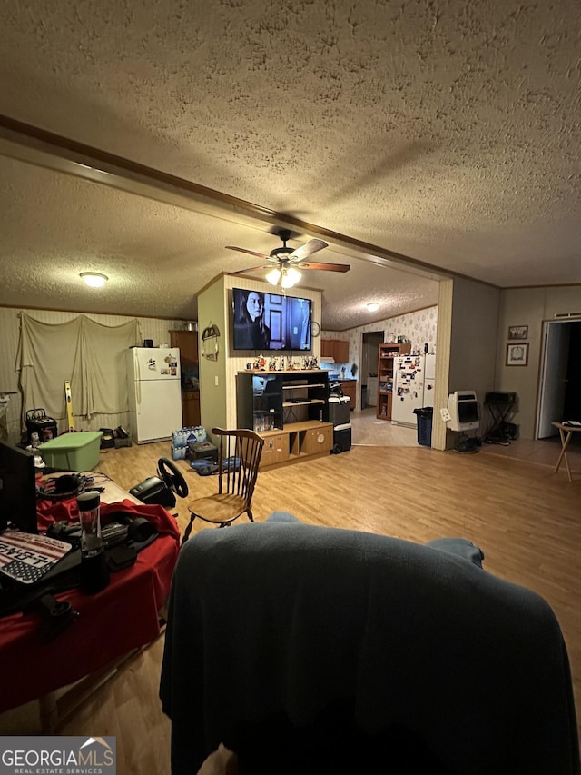 living room featuring a textured ceiling, wood finished floors, and a ceiling fan