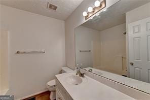 full bath with a shower, visible vents, vanity, and toilet