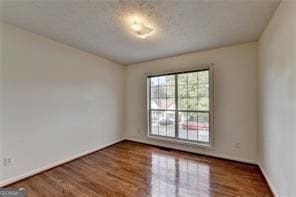 empty room with baseboards and wood finished floors