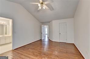 interior space with ceiling fan, vaulted ceiling, and wood finished floors