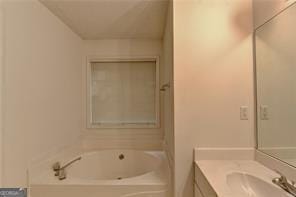 full bath with a garden tub and vanity