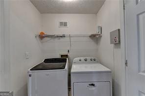 clothes washing area featuring laundry area, washing machine and dryer, and visible vents