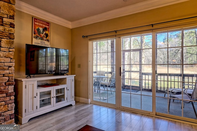 entryway with crown molding, baseboards, and wood finished floors