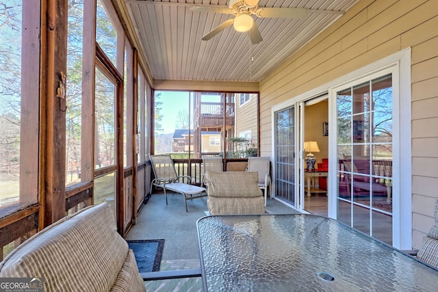 sunroom featuring wood ceiling and a ceiling fan