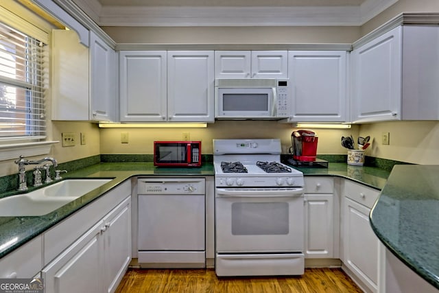 kitchen with white appliances, white cabinetry, light wood-style floors, and a sink