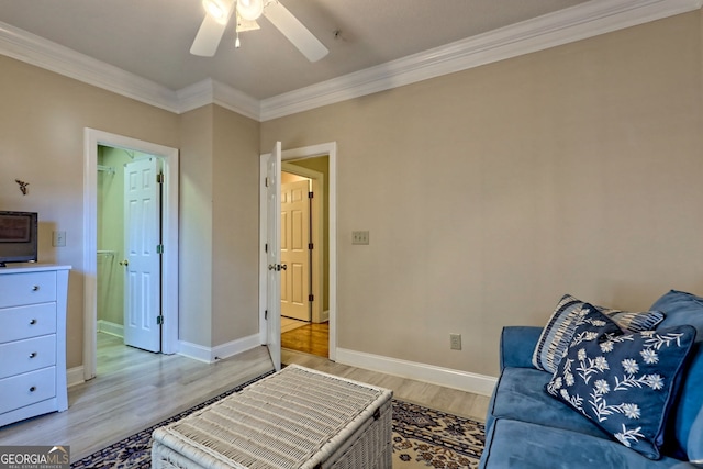 living area featuring baseboards, light wood finished floors, a ceiling fan, and crown molding